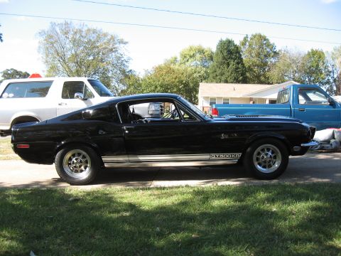 1968 Shelby GT500 - Side view of a black 1968 Shelby GT500KR Mustang with racing stripes.