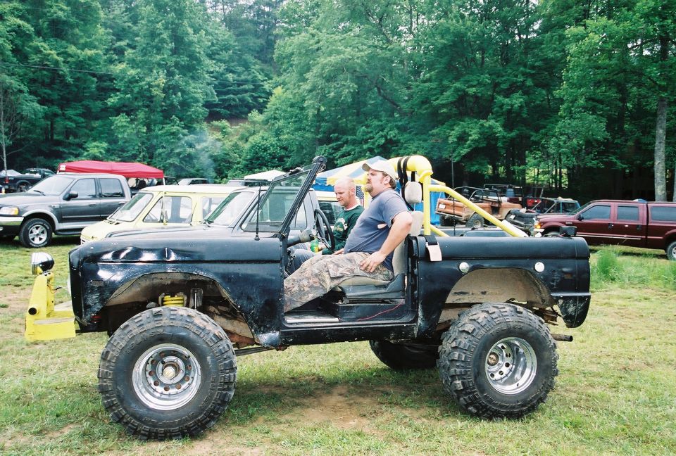 Black Ford Bronco with lifted suspension and large tires, driver seated inside