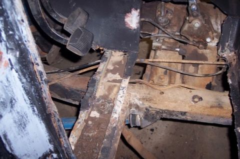 1976 Ford Bronco - Close-up of a corroded vehicle interior showing the floor pan and pedals.