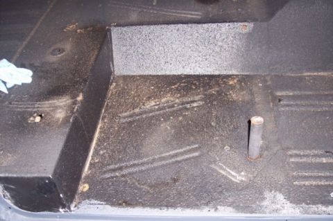 1976 Ford Bronco - The interior floor of a vehicle shows a metal hump and a protruding post, with a "Supermotors.net" watermark at the bottom.