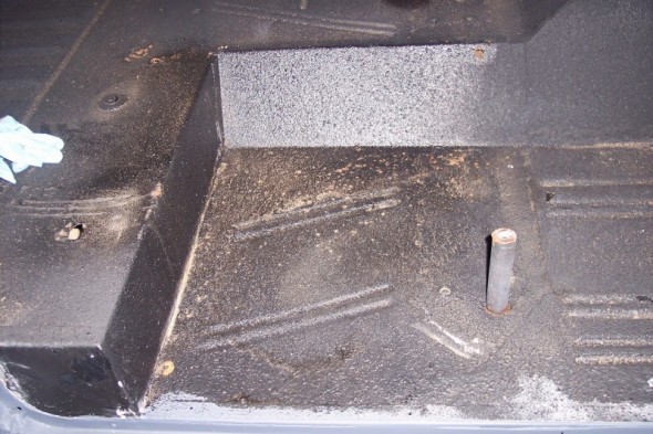 Interior floor of a vehicle with a metal hump and a post