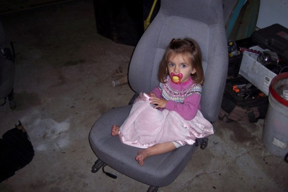 Child sitting in a car seat with a pacifier