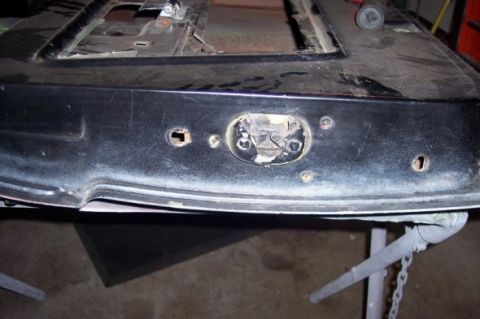 1976 Ford Bronco - Close-up of a vehicle's black tailgate, showing wear and tear around the latch area.