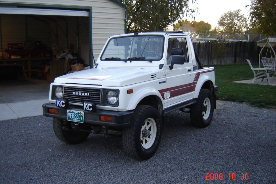 White Suzuki Samurai with red side stripes and KC lights