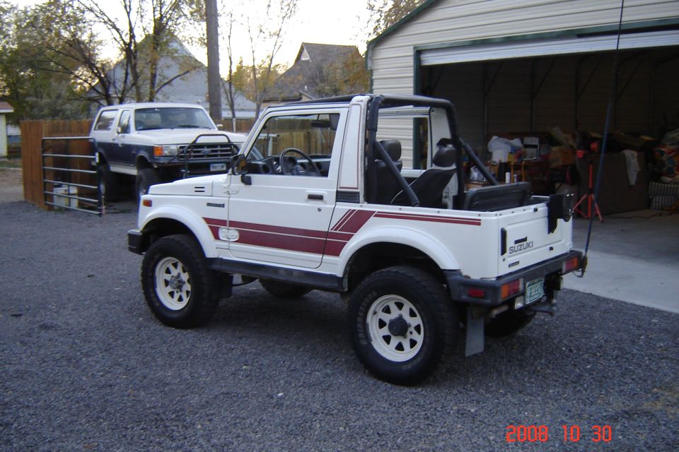 White Suzuki Samurai with red stripes, rear 3/4 view