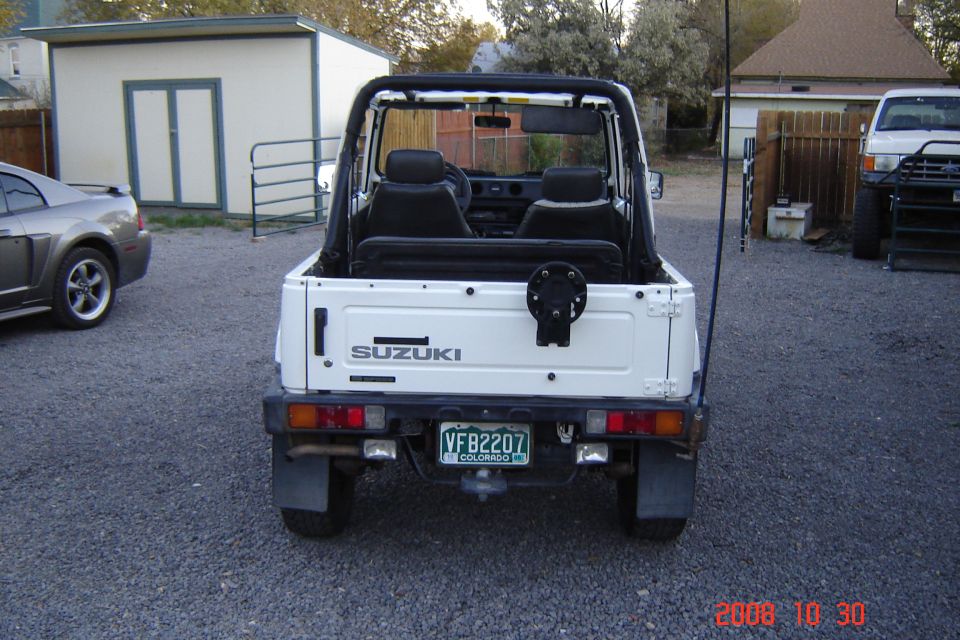 White Suzuki Samurai rear view with spare tire mount and Colorado license plate VFB2207