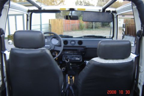 1988 Ford Bronco - The interior of a Suzuki Samurai is shown, with a view of the dashboard and seats.