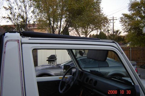 1988 Ford Bronco - Interior view of a white convertible SUV, showing the dashboard and steering wheel. The Supermotors.net logo is present in the lower right…