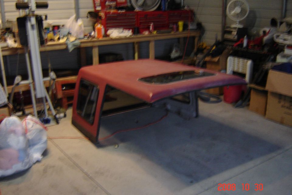 red truck cap sitting on garage floor