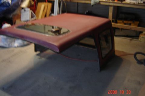 1988 Ford Bronco - A red hardtop with a sunroof is shown in a garage setting.
