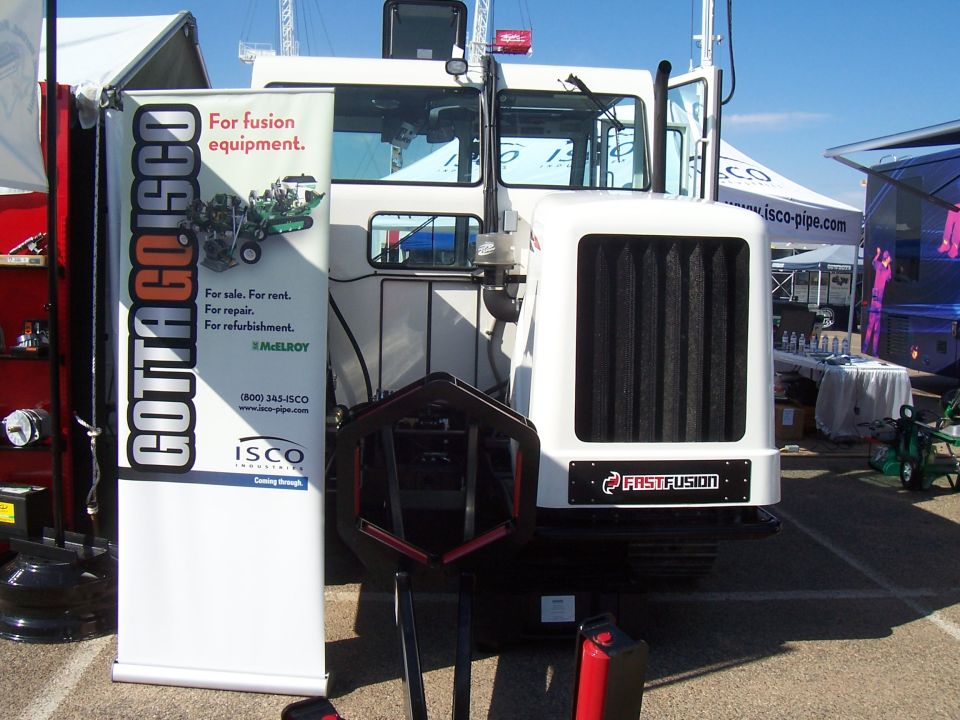 Front view of a white industrial vehicle with a FastFusion logo and a banner for ISCO Industries