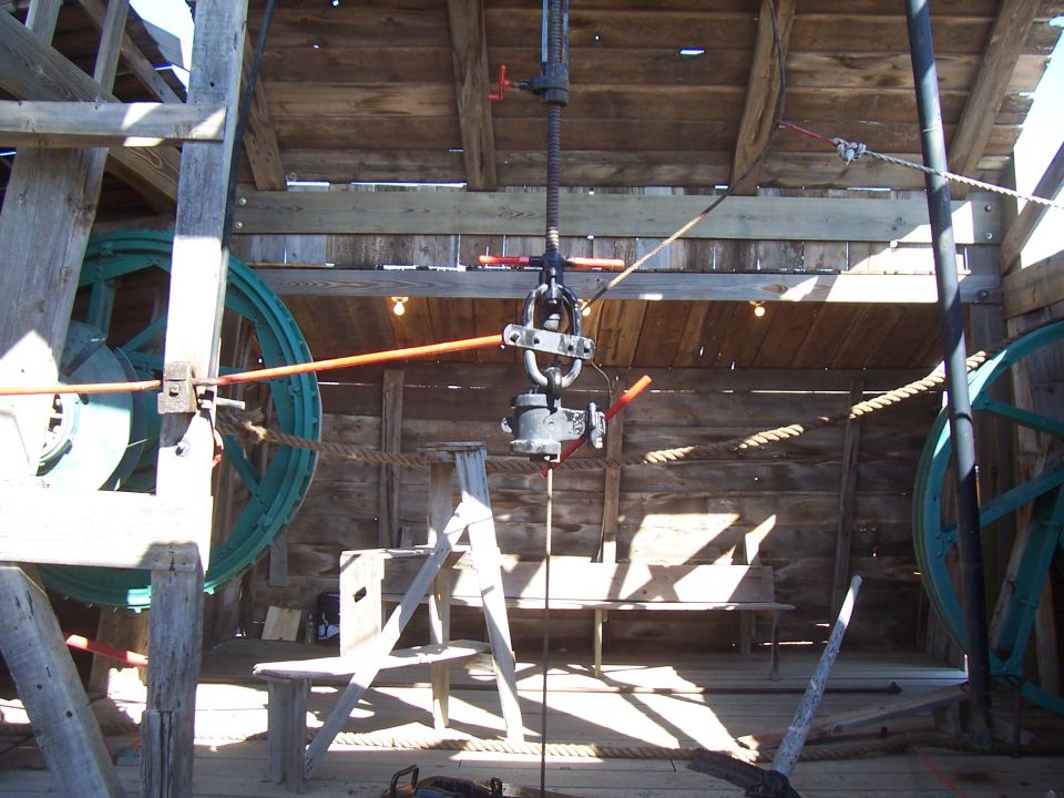 Wooden structure with large spools, ropes, and a hoist mechanism, likely for oil extraction