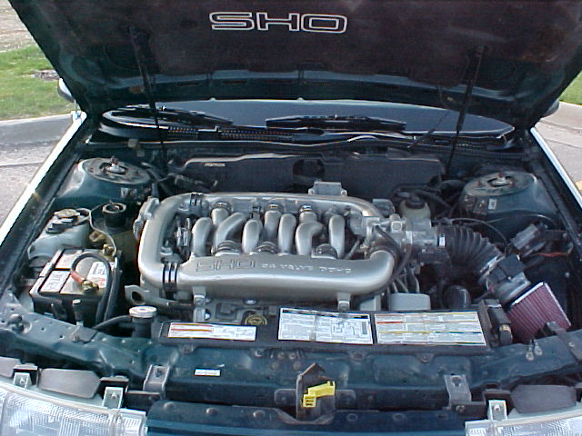 Open engine bay with SHO V6 intake manifold, K&N cone filter and battery