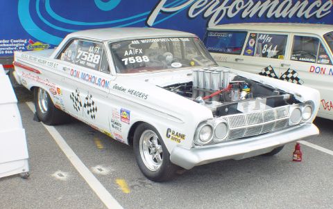 1969 Ford Fairlane - A vintage drag car, likely a 1962 model, is prepped for a race with its hood open, revealing the engine and intake manifold.