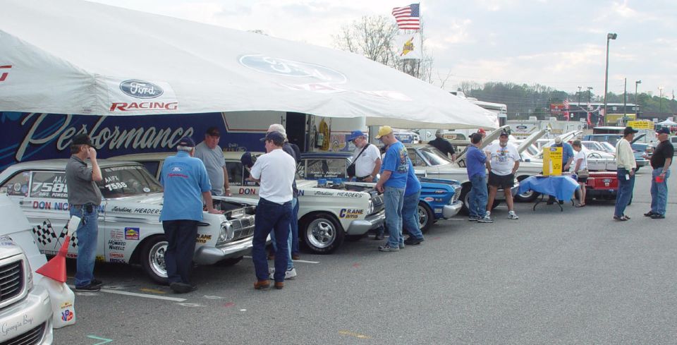 1969 Ford Fairlane race car and other classic Fords under a Ford Performance tent at an event