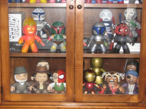 1991 Ford Bronco - Action figures from various franchises are neatly arranged on shelves inside a wooden cabinet.