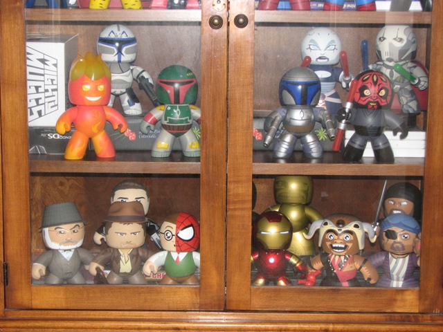 Wooden glass cabinet displaying Star Wars and Marvel Mighty Muggs figures