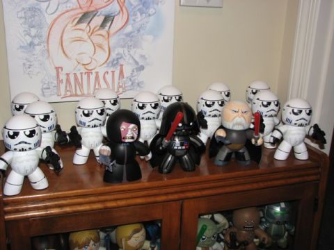 1991 Ford Bronco - A collection of Star Wars figures, including Darth Vader and Stormtroopers, are displayed on a wooden shelf with a 'Fantasia' poster in the…