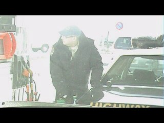 1991 Ford Crown Victoria - A person stands at a gas pump next to a car during what appears to be a snowy day.
