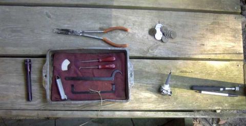 1997 Ford Taurus - A collection of automotive tools and small parts are arranged on a weathered wooden surface.