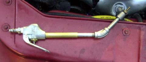 1997 Ford Taurus - An air tool is attached to the engine bay of a red vehicle.