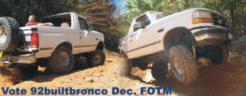 1992 Ford Bronco - Two white 1992 Ford Broncos navigate a challenging off-road course, demonstrating their capabilities.