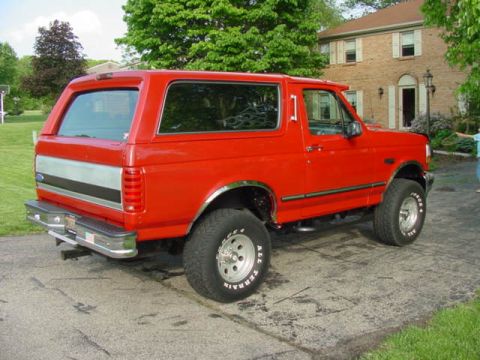 1992 Ford Bronco - This red 1992 Ford Bronco is captured in a 3/4 front view, its classic SUV design.