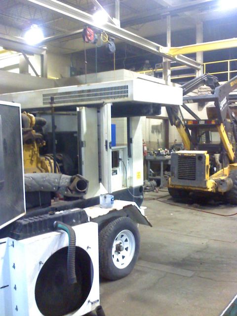 1992 Ford Bronco - A trailer-mounted generator and a yellow skid steer loader are parked inside a workshop.