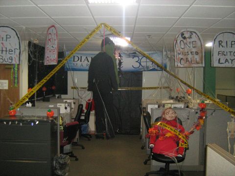 1988 Mercury Grand Marquis - Office cubicles are decorated for Halloween with caution tape, tombstone cutouts, and spooky figures.
