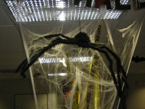 1988 Mercury Grand Marquis - A large spider decoration hangs amidst fake cobwebs and caution tape, creating a spooky Halloween scene.