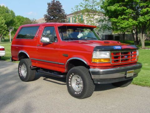 1992 Ford Bronco - This red Ford Bronco is shown from a three-quarter front view on a sunny day.