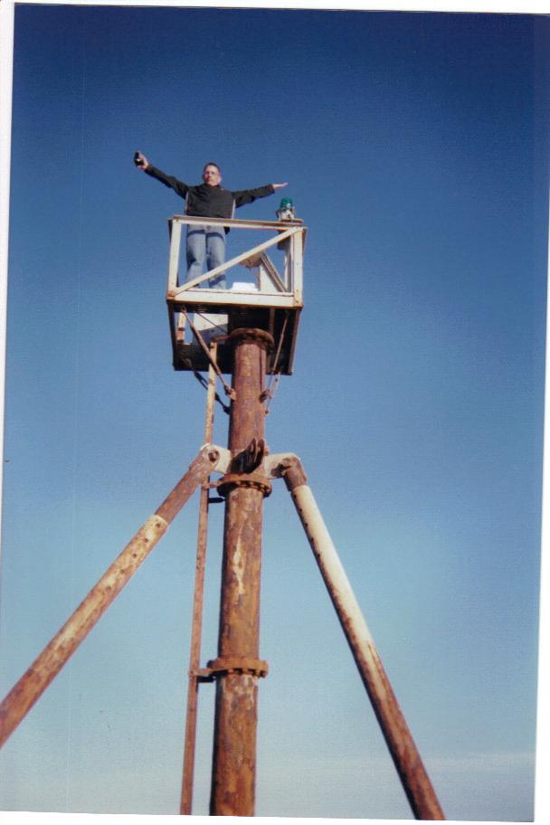 guy in a lift with arms out, blue sky