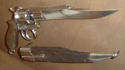 1990 Ford Bronco - A close-up view of a firearm with an integrated bayonet and its accompanying sheath.