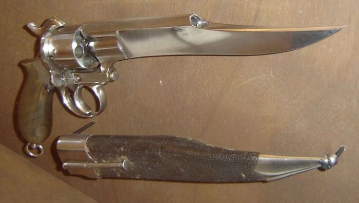 Revolver with a long, sharp bayonet attached to the barrel. A leather sheath is below