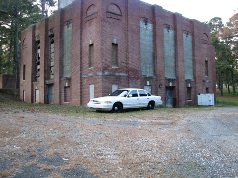 1996 Ford Crown Victoria - A white 1996 Ford Crown Victoria is parked in front of an abandoned brick building.