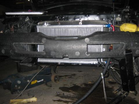 1996 Ford Thunderbird - The front of a car is shown with the radiator exposed, supported by a hydraulic jack.