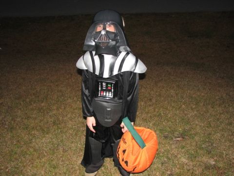 1991 Ford Bronco - Child in Darth Vader costume trick-or-treating with a pumpkin bucket.