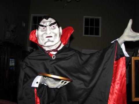 1991 Ford Bronco - A vampire decoration stands indoors, dressed in a cape and holding a tray.