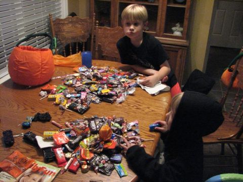 1991 Ford Bronco - Two children examine a large pile of Halloween candy spread across a wooden table.