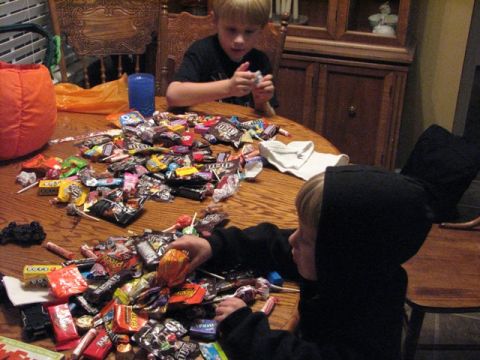 1991 Ford Bronco - Two children sort through a large pile of Halloween candy spread across a wooden table.