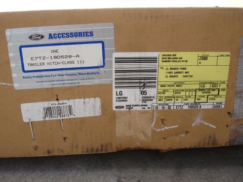 1992 Ford F-350 - A cardboard box containing a Ford trailer hitch, with various labels indicating part number, shipping information, and origin.