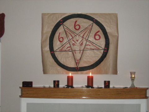 1988 Mercury Grand Marquis - A pentagram decoration with a goat head and the number 666 is displayed above a mantelpiece with candles.