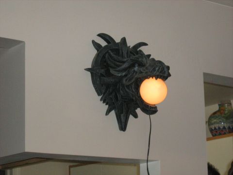 1988 Mercury Grand Marquis - A wall sconce shaped like a dragon head holds a glowing orb in its mouth.