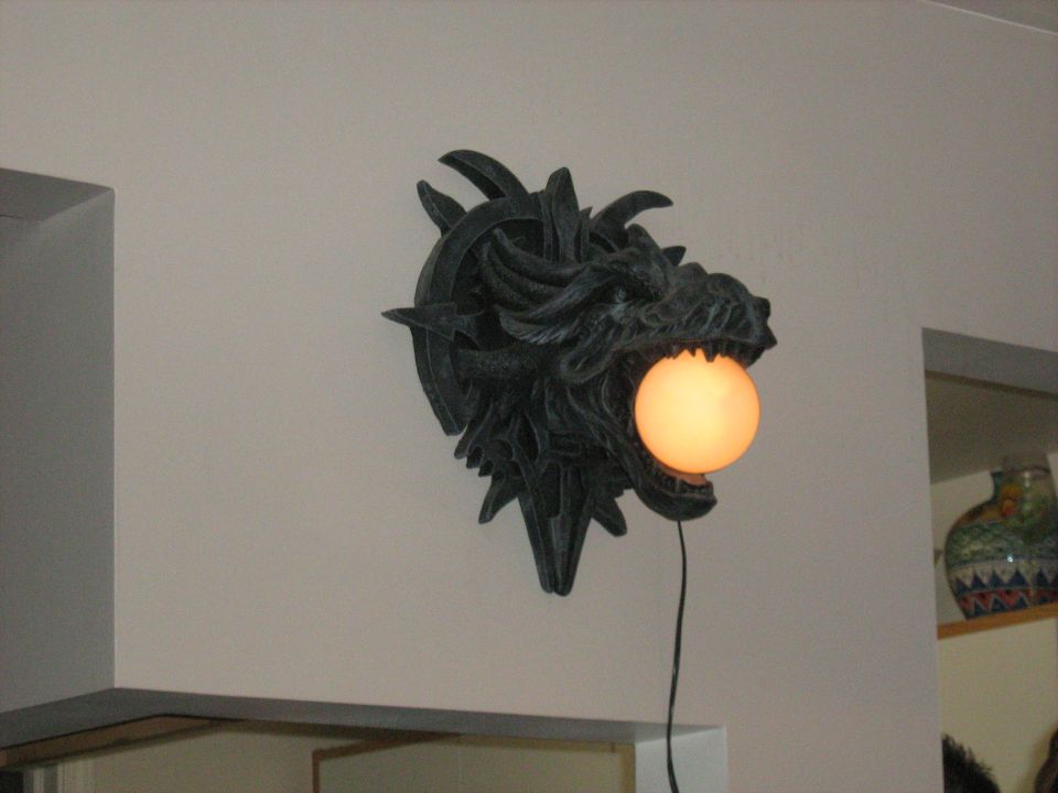 Dragon head wall sconce with a glowing ball in its mouth