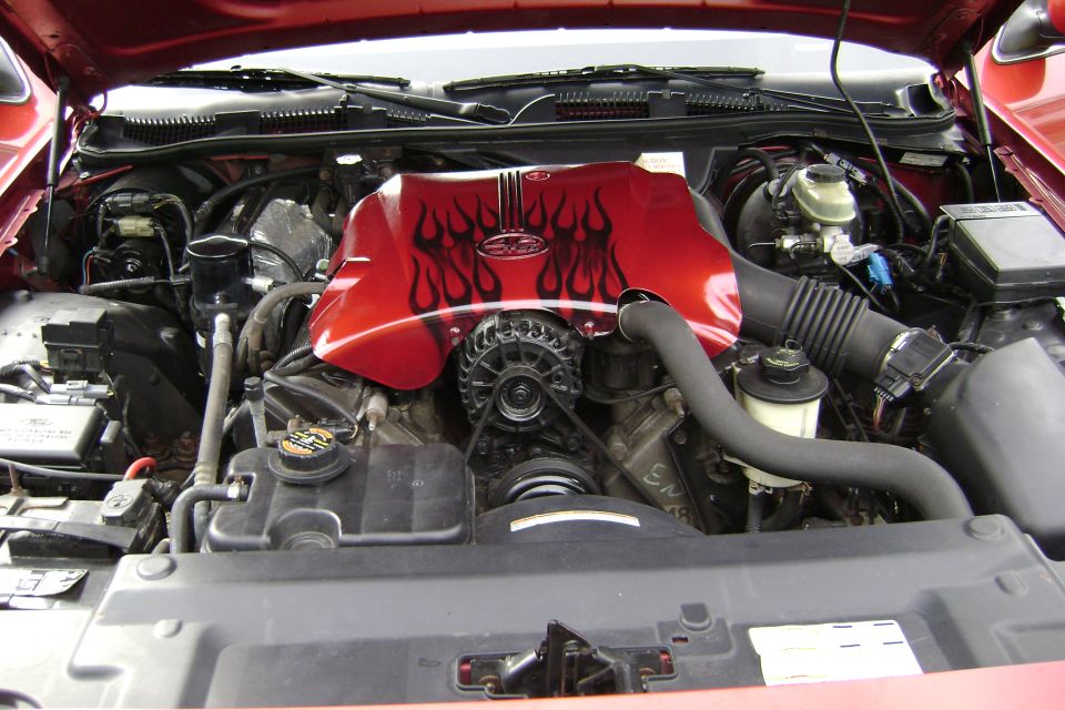 Engine bay of red car with custom flame-painted 4.6 V8 intake cover