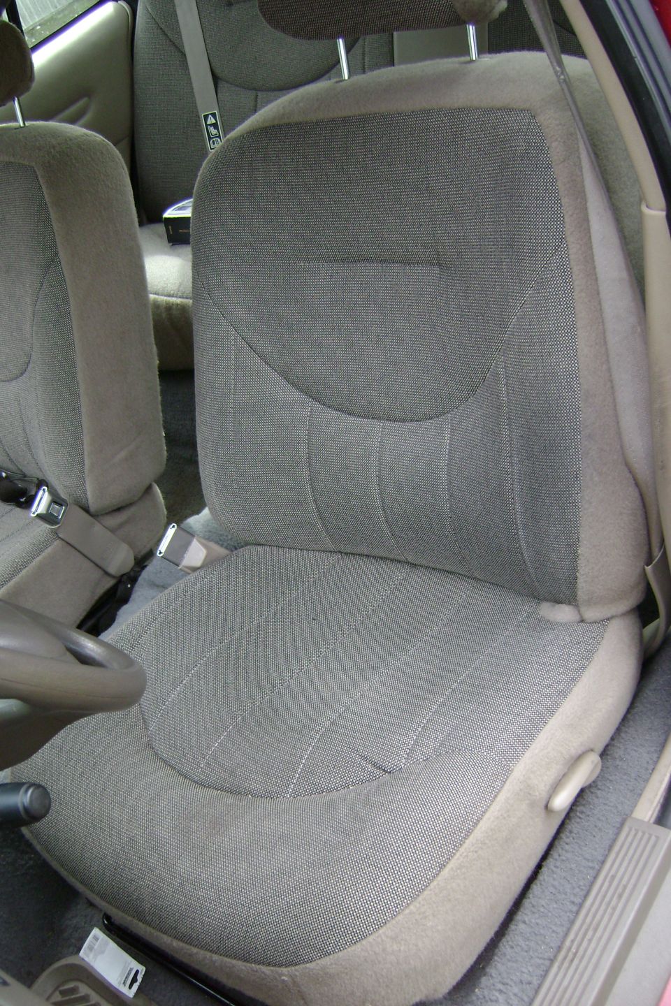Beige cloth front bucket seat inside a car interior