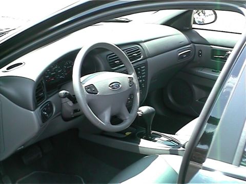 2002 Ford Taurus - The interior of a 2002 Ford Taurus is captured, highlighting the driver's side controls and dashboard.