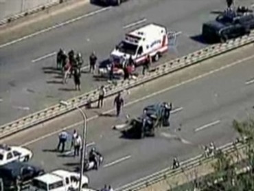 1993 Ford Bronco - Emergency responders attend to a multi-vehicle accident on a highway, including an overturned car.