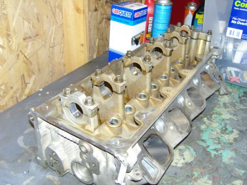 2007 Ford Mustang - A close-up view of an engine cylinder head, with automotive parts and supplies in the background.
