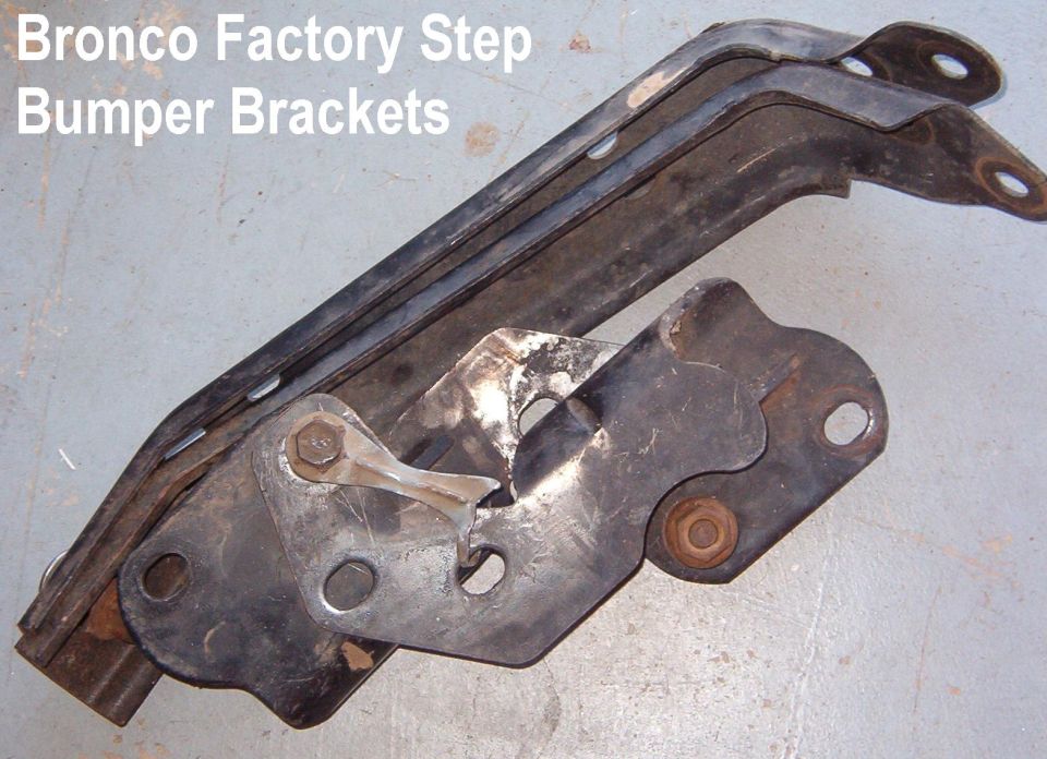 Bronco factory step bumper brackets laid on a garage floor